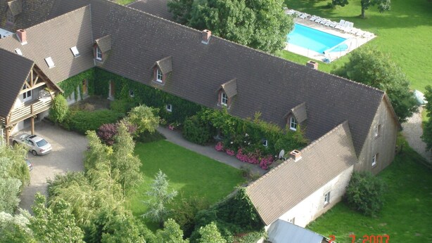 A large, single-story building with a tiled roof, surrounded by lush greenery and a swimming pool. - Quend-Plage Apartment with Pool (Quend-Plage)