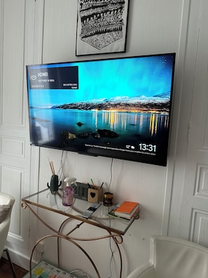 Un téléviseur à écran plat fixé au mur, diffusant un paysage pittoresque.