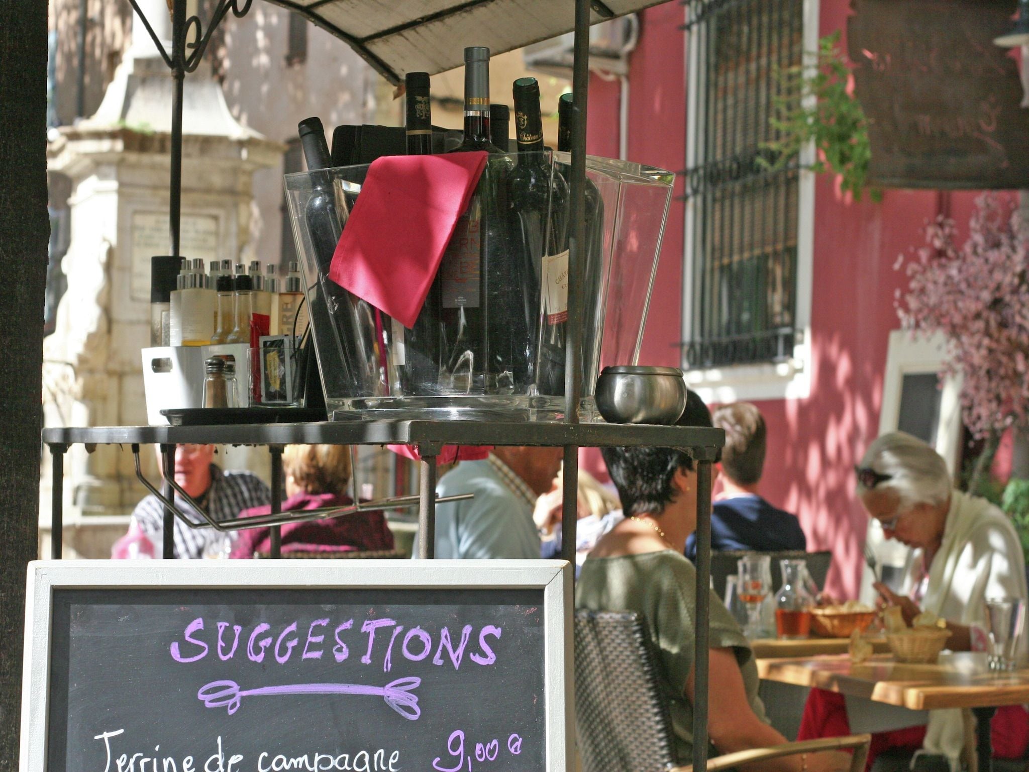 A chalkboard sign with 'SUGGESTIONS' and 'Terrine de campagne 9,00€' written on it.