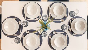 A table set for six with white plates, blue napkins, and silverware. - Your Stylish, Spacious 4 Bedroom, 3 Bathroom, home-from-home near all amenities. (Colchester)