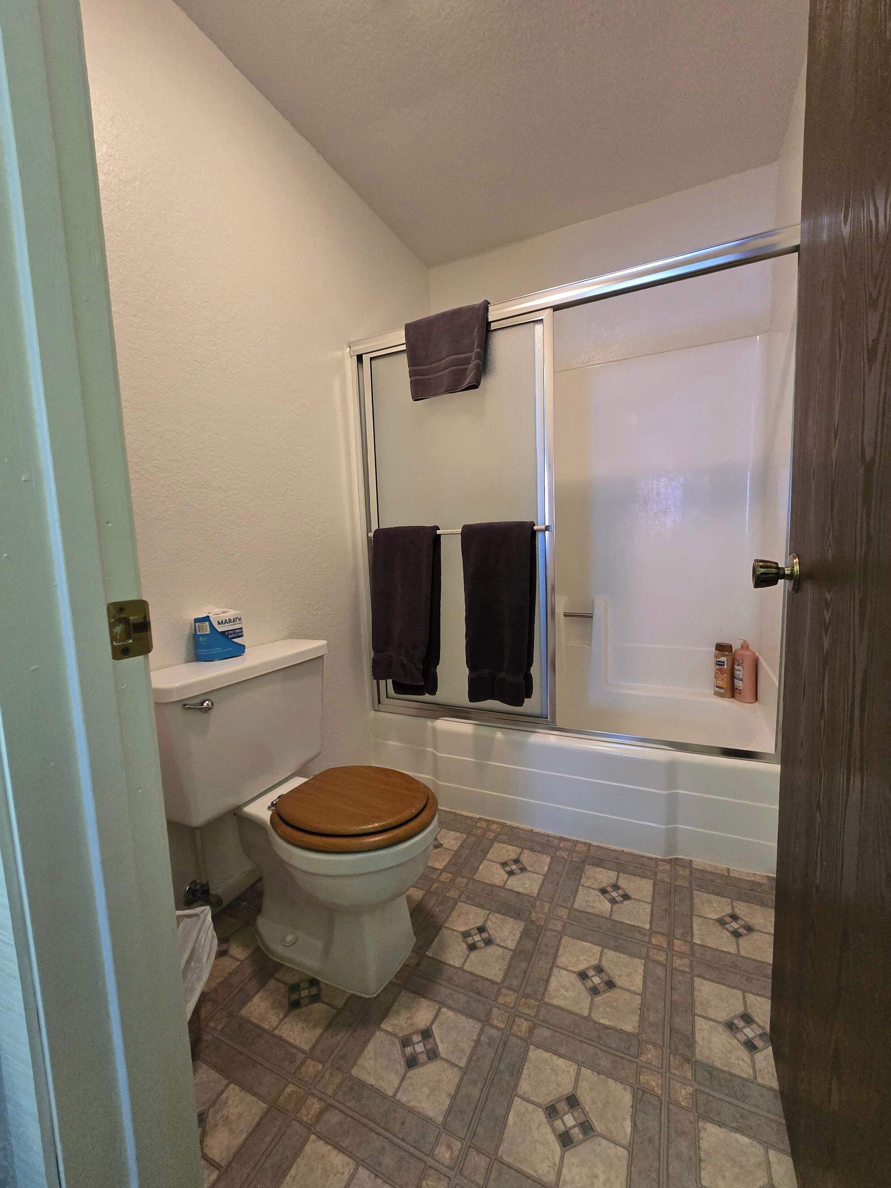 Une petite salle de bain comprenant des toilettes, une douche et une baignoire.