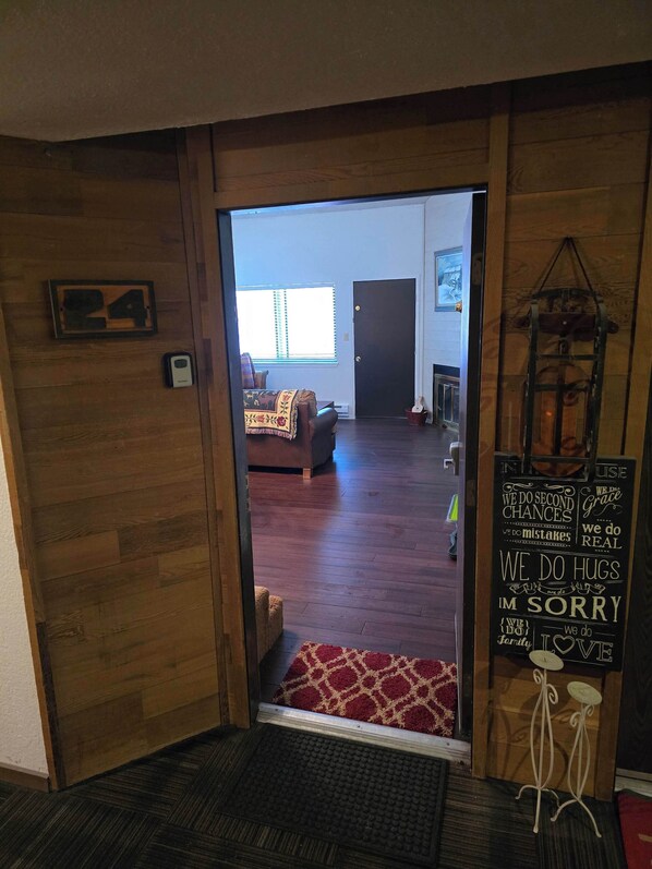Een houten interieur met een deur naar een woonkamer.