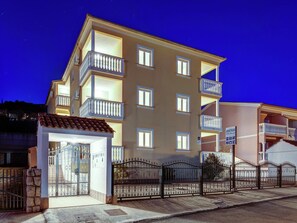 A multi-story hotel with balconies, a gated entrance, and a sign indicating it is an apartment hotel. - Apartment in Dramalj near the Sea (Dramalj)