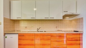 A kitchen with white cabinets, a sink, and a stove.