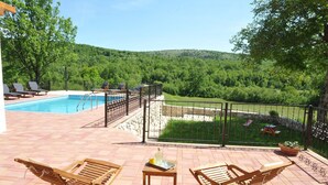 A pool area with lounge chairs and a view of a forested hillside. - Villa in Tijarica with Private Pool (Tijarica)
