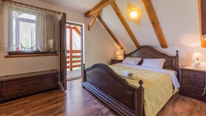 A bedroom with a wooden bed, a nightstand, a dresser, and a window with curtains. - Holiday Home in Brod Moravice with Pool (Brod Moravice)