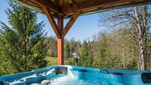 A hot tub under a wooden structure with a forest view. - Holiday Home in Brod Moravice with Pool (Brod Moravice)