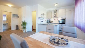 A modern kitchen with white cabinets, a stainless steel range hood, and a built-in oven. - Apartment in Zadar with free wifi (Zadar)