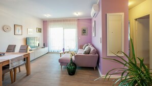 A living room with a sofa, a dining table, and a TV. - Apartment in Zadar with free wifi (Zadar)