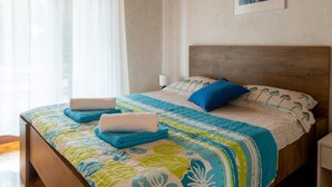 A bedroom with a wooden bed, a blue and green patterned bedspread, and a blue pillow. - Spacious Holiday Home in Verteneglio (Brtonigla)