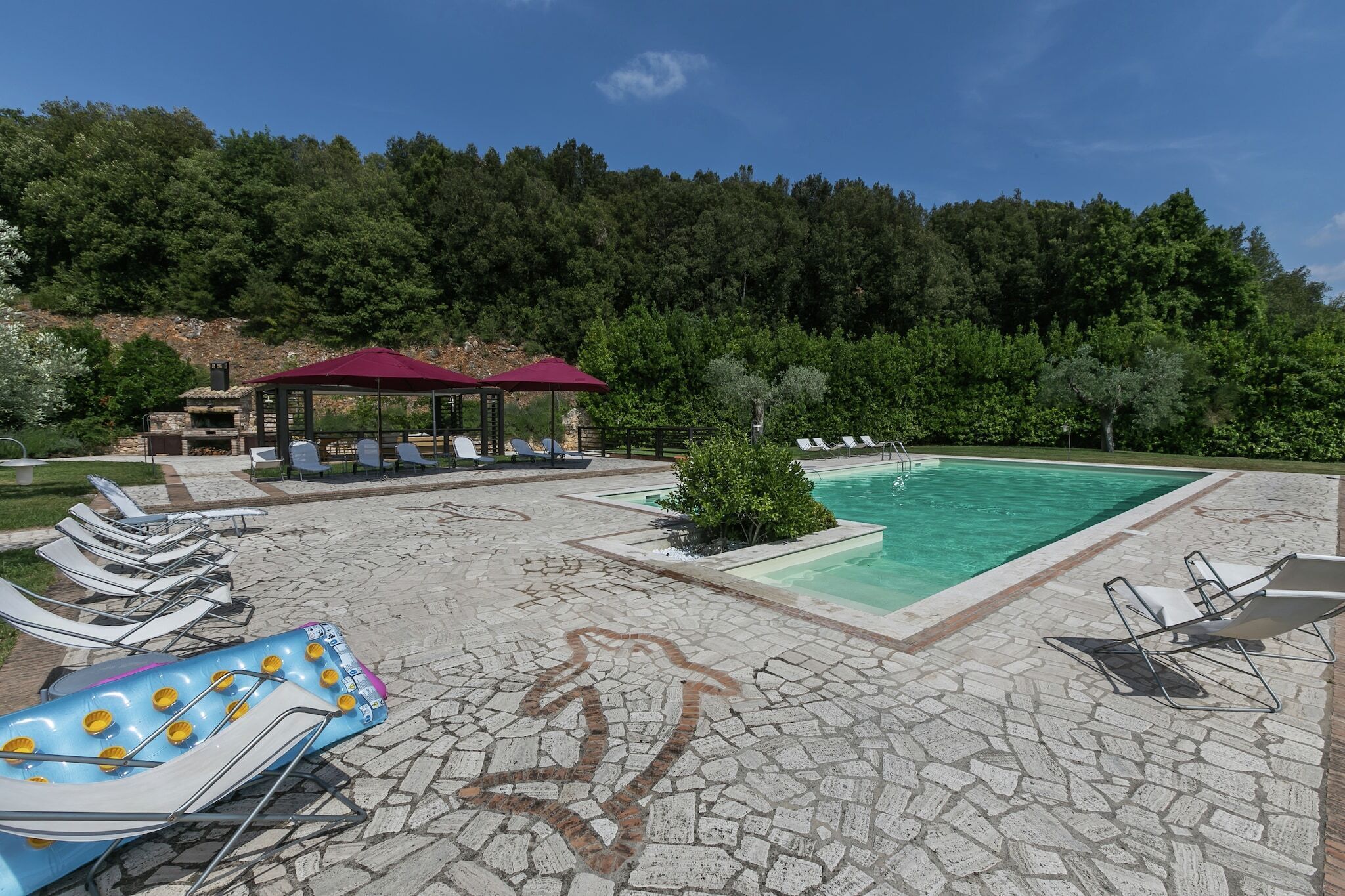 Zona de piscina amb gandules, una piscina petita i un cobert.