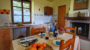 Cozinha com mesa de jantar posta para dois, janela e lareira.