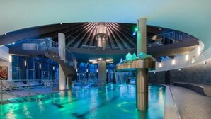En stor inomhuspool med en central fontän och flera våningar av balkonger.