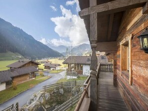 Ein Holzbalkon mit Blick auf ein Dorf und Berge.