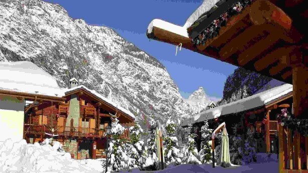 A snow-covered mountain lodge with wooden cabins and a ski slope in the background. - Apartment in Antey with Stunning Mountain Views (Antey st. Andre)