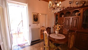 A dining area with a chandelier, wooden cabinet with trophies, and a table with chairs.