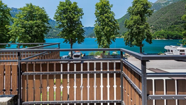 A wooden deck with a view of a lake and mountains. - Apartment in Ledro by Lake & Dolomites (Ledro)