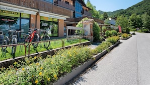 A building with a storefront, outdoor seating, and bicycles parked in front. - Apartment in Ledro by Lake & Dolomites (Ledro)