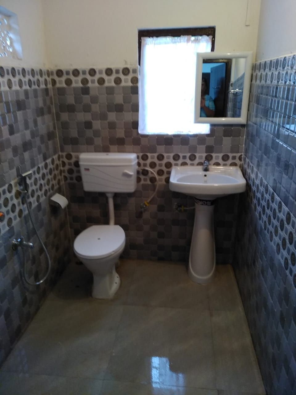 A small bathroom with a toilet, sink, and shower.