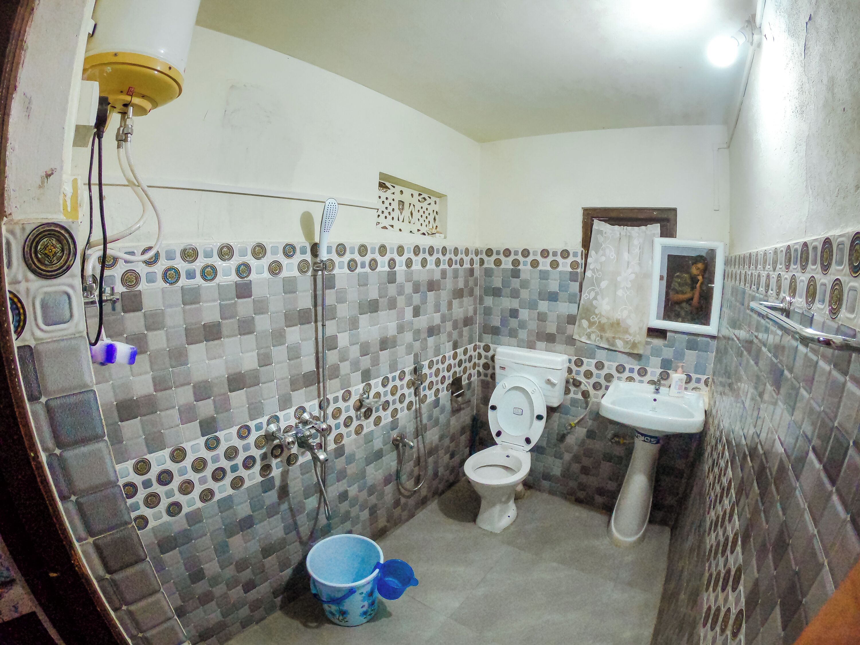 Une salle de bain avec une douche carrelée, des toilettes et un lavabo.