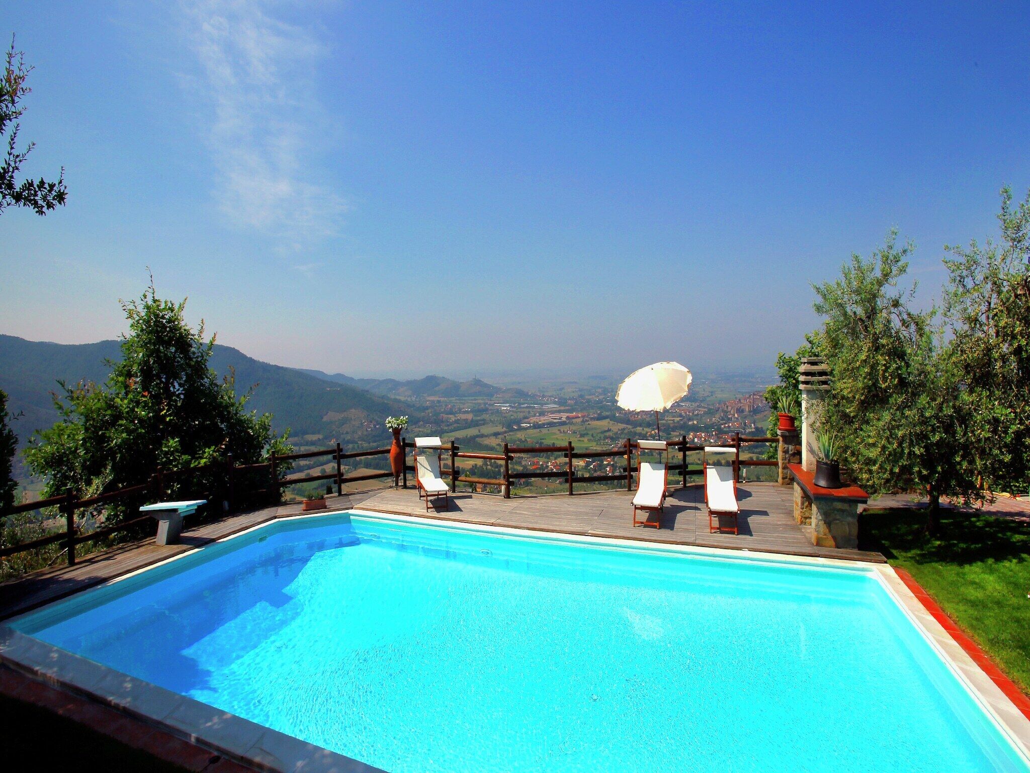 A swimming pool with lounge chairs and a view of the countryside.