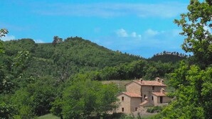 A rustic stone house surrounded by lush greenery and hills. - Farmhouse in Marche with Pool and Views (Mercatello sul Metauro)