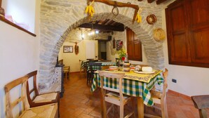 A rustic dining area with stone walls, wooden beams, and checkered tablecloths. - Farmhouse in Marche with Pool and Views (Mercatello sul Metauro)