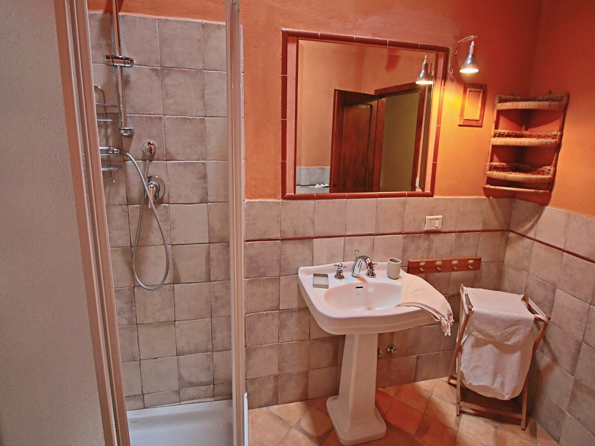 Un baño con ducha, lavabo y espejo.