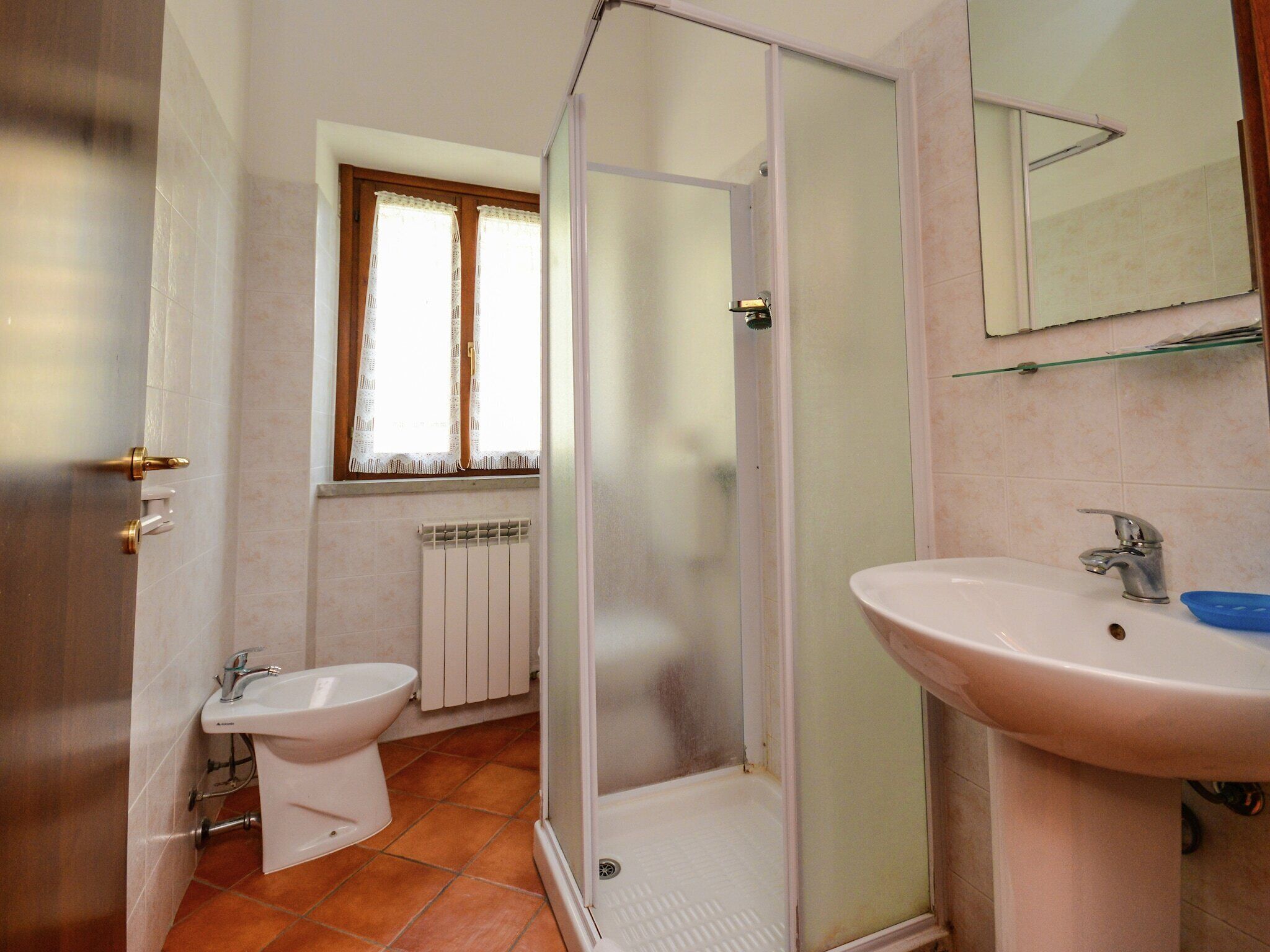 A bathroom with a shower, a sink, and a toilet.