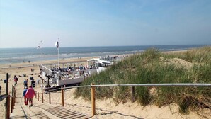 A beachside walkway leading to a beach area with a lifeguard station and a boat dock. - Apartment in Bergen aan Zee near the Beach (Bergen aan zee)
