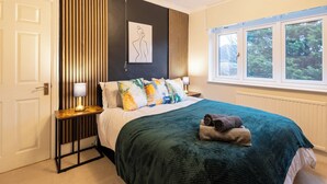 A bedroom with a bed, pillows, a bedside table with lamps, a window, and a radiator. - Cozy home in Bristol,Contractors, Relocation, Families, Parking, WIFI,SMARTTV (Bristol)