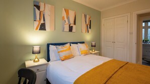 A bedroom with a bed, two bedside lamps, a chair, and abstract wall art. - Cozy home in Bristol,Contractors, Relocation, Families, Parking, WIFI,SMARTTV (Bristol)