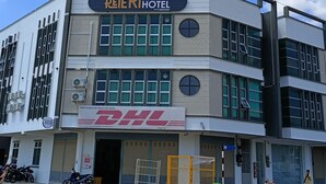 A hotel named 'Peteri Boutique Hotel' with a DHL sign, large windows, and a clear sky. - Keteri Boutique Hotel (Kangar)