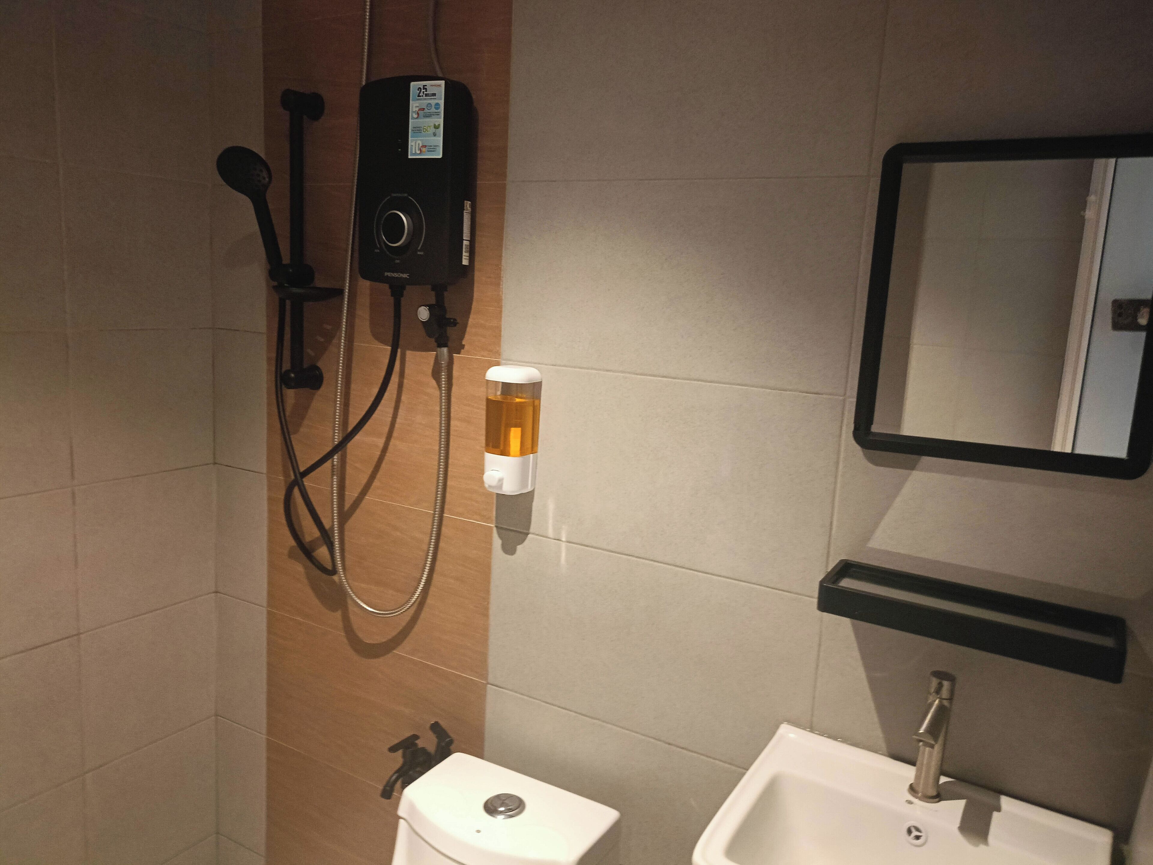 Een badkamer met douche, toilet, wastafel en spiegel.