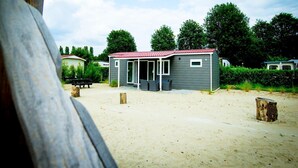 A small, single-story building with a red roof and a covered patio area. - Chalet near Loonse and Drunense Duinen (Udenhout)