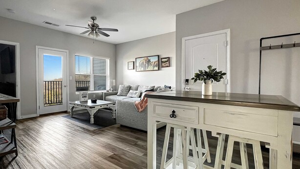 A living room with a sofa, coffee table, and a white cabinet with stools. - 3111 Close to Silver Dollar City, Save 10% on tix (Branson)