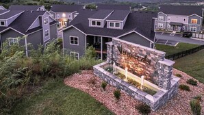 A residential area with multiple houses, a stone fireplace, and a well-maintained lawn. - 3111 Close to Silver Dollar City, Save 10% on tix (Branson)