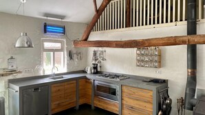A modern kitchen with wooden cabinets, a built-in oven, and a gas stove. - Farmhouse in Stramproy near Forest (Stramproy)