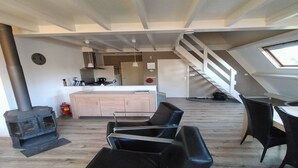 A modern loft with a kitchen, dining area, and a staircase leading to an upper level. - Chalet in Tyrol near Ski Slope (Stramproy)