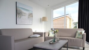 A modern living room with two sofas, a coffee table, and a painting on the wall. - Charming Retreat for Your Escape (Bemelen)