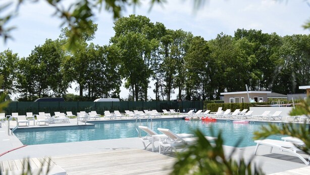 A pool area with multiple lounge chairs and a wooden deck. - Charming Retreat for Your Escape (Bemelen)