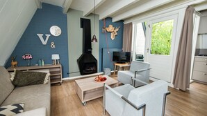 Un salon moderne avec une cheminée, un téléviseur et un coin repas.