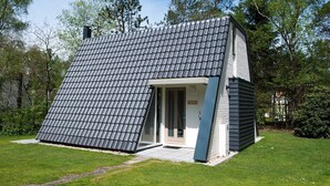Une maison moderne avec un toit en pente et un petit porche.