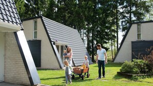 Un quartier résidentiel avec des maisons, une pelouse et une structure métallique adossée à un bâtiment.