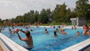 A swimming pool with people enjoying the water.