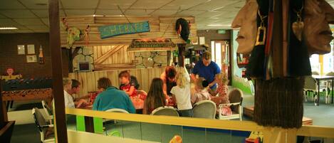 A restaurant with a wooden bar area, a sign reading "SHERIFF BILLIARDS", and a children's play area with toys and tables.