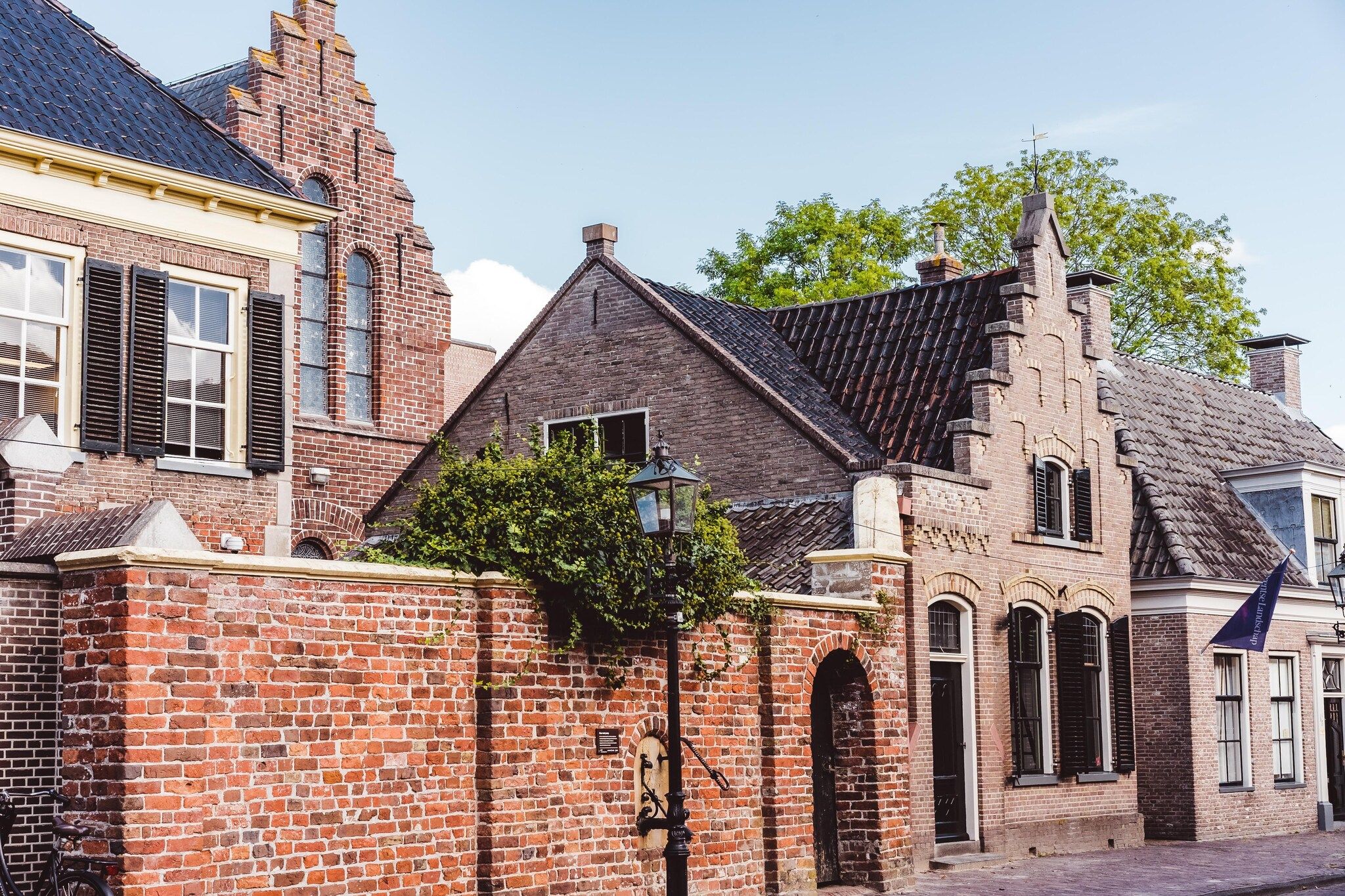 Un bâtiment historique à la façade en briques, doté de fenêtres en arc et d’un toit à deux versants de style traditionnel.