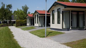 A row of modern, single-story buildings with red roofs and large windows, likely part of a hotel or resort.