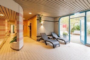 Relax in a serene indoor space with lounge chairs and a potted plant.