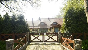 A cobblestone entrance to a building with a traditional architectural style, featuring a wooden gate and stone walls. - Seaside Villa with Sauna (Karwieńskie Błoto Drugie)